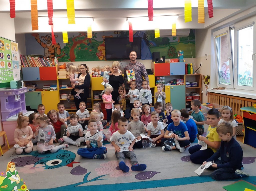 Przedszkolaki na zdjęciu grupowym z przedstawicielem PUK.